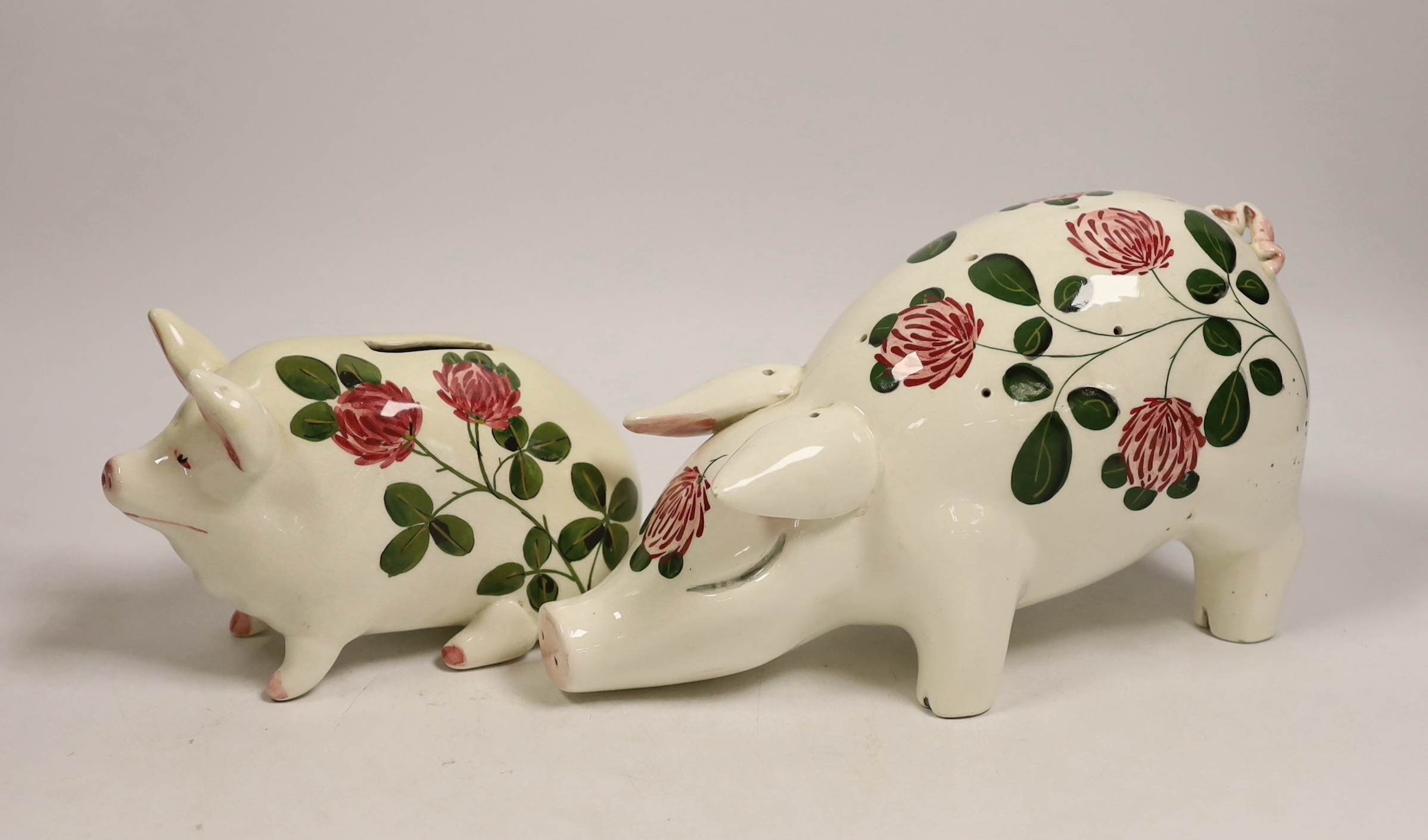 A Plichta rose decorated pig money box, 16cm, and a Plichta rose decorated hatpin holder pig, 23cm and two other Plichta pigs